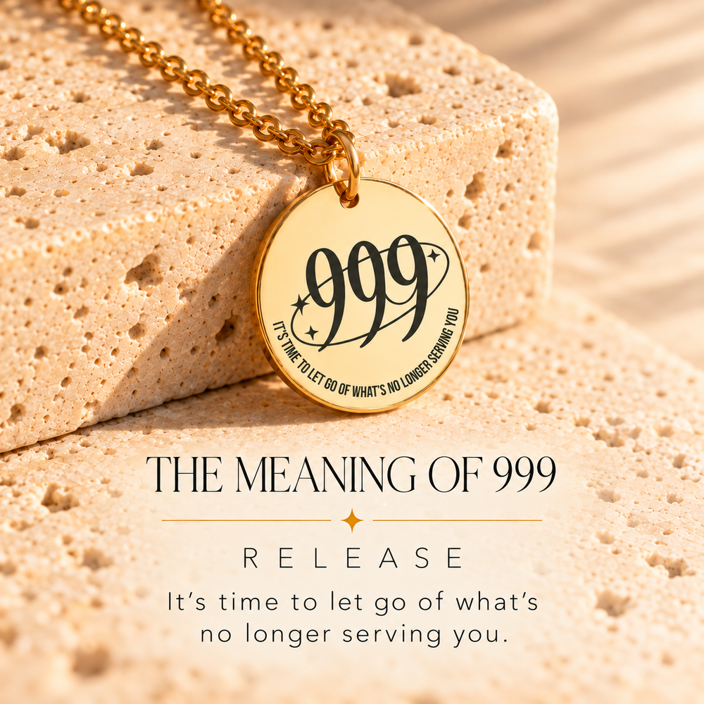Round gold 999 angel number pendant on sunlit stone, engraved 'let go of what's no longer serving you' — 999 means release
