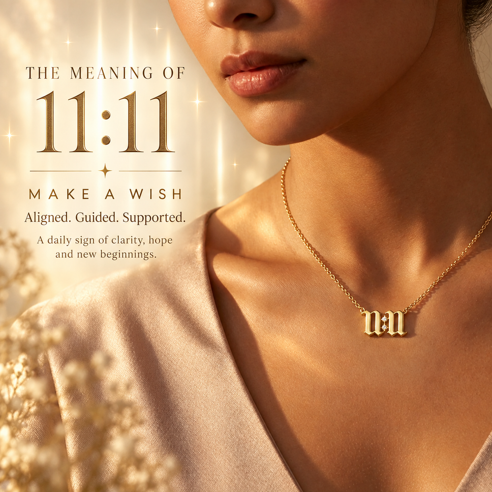Gold 11:11 necklace in Old English script worn over a blush satin top — 11:11 is a sign to make a wish