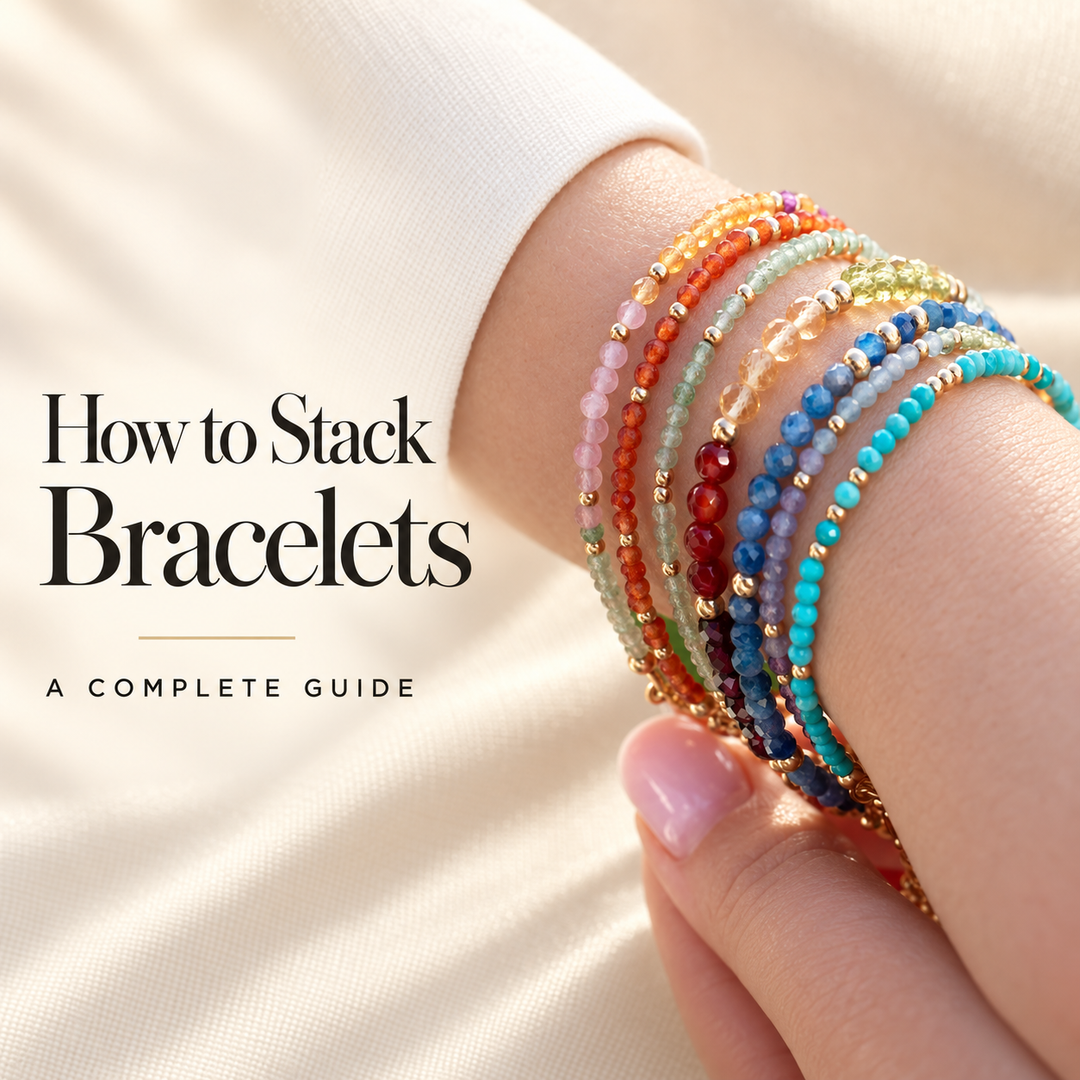 How to Stack Bracelets, a complete guide — a wrist stacked with seven fine beaded gemstone bracelets in pink, orange, green, red, blue and turquoise with gold accents