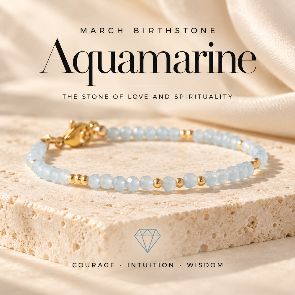 March Birthstone Aquamarine, the Stone of Love and Spirituality — a pale blue aquamarine and gold beaded bracelet on travertine, captioned Courage · Intuition · Wisdom