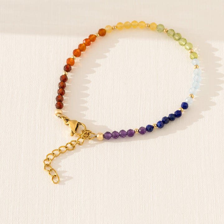 Close-up of natural 7 chakra stones — Garnet, Carnelian, Yellow Agate, Peridot, Aquamarine, Lapis Lazuli, Amethyst