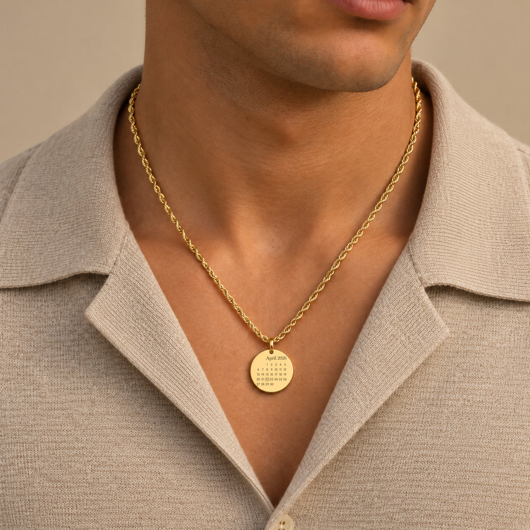 Man wearing a gold calendar necklace on a rope chain
