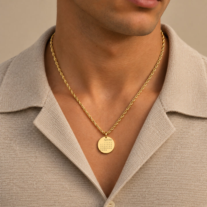 Man wearing a gold calendar necklace on a rope chain