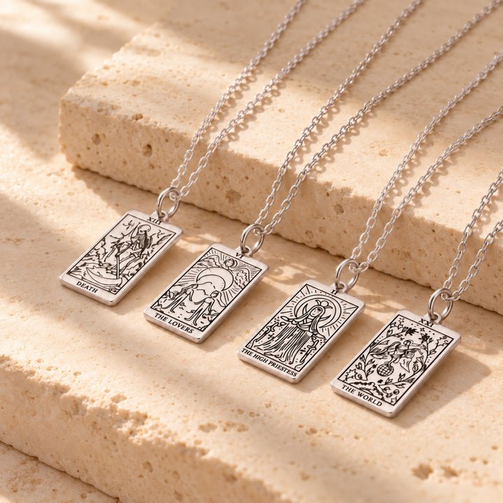 Four tarot card necklaces in silver, layered together