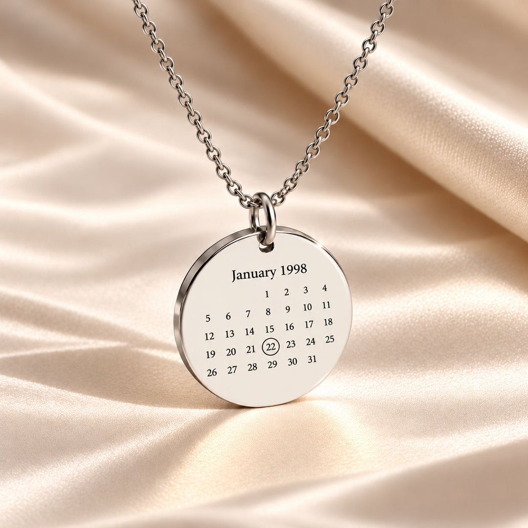 Silver calendar necklace engraved with January 1998 and the date circled