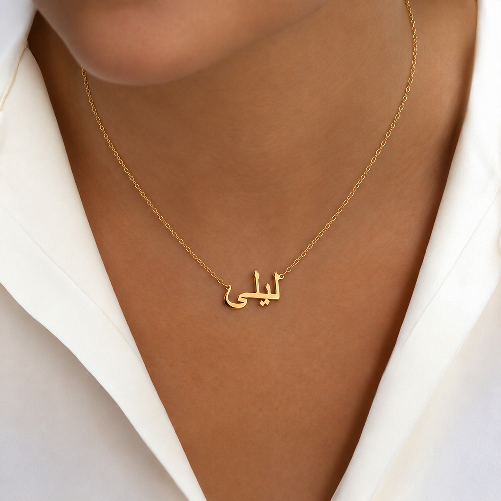 Gold Arabic name necklace worn on model, name cut in Arabic script