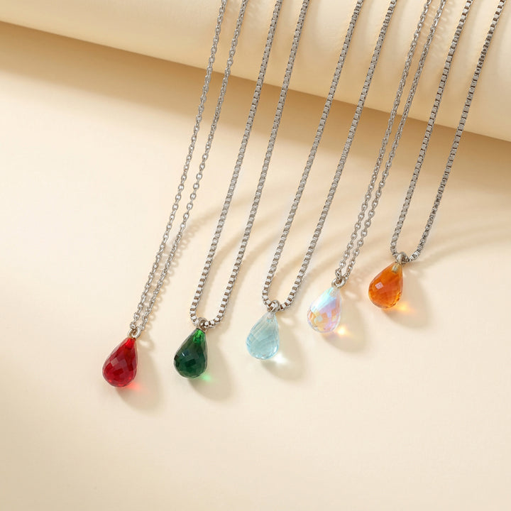 Teardrop crystal birthstone necklaces in silver styled flat lay