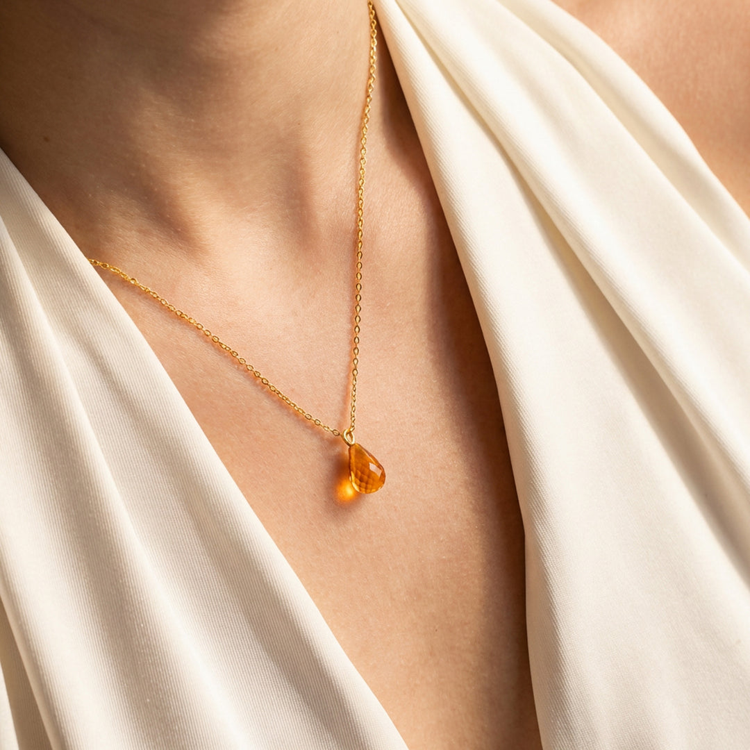 Crystal birthstone teardrop necklace styled on woman — gold and silver