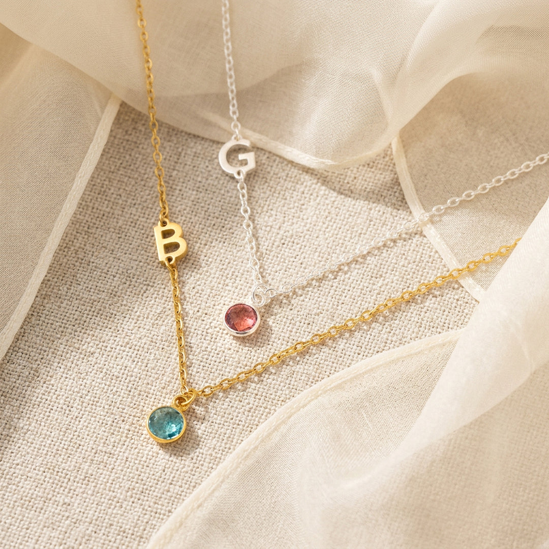 Dainty sideways initial necklace with letter charm and crystal birthstone — close-up