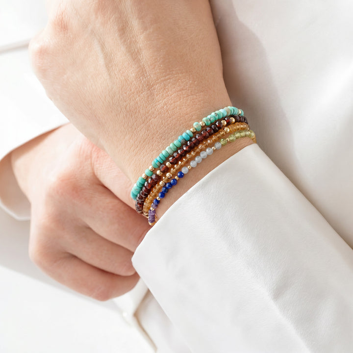 14K gold filled Arizona turquoise bracelet on wrist, stacked with other Abiza bracelets — December birthstone