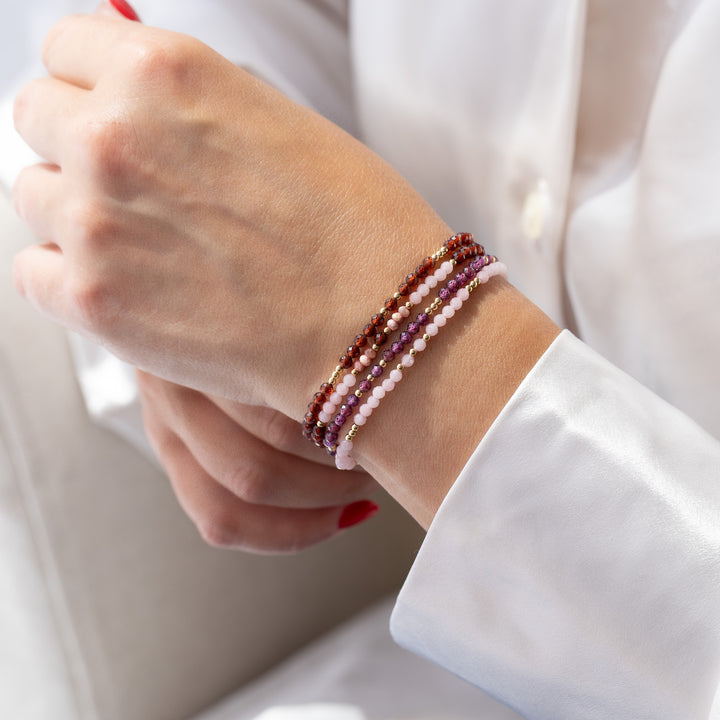 Garnet bracelet on wrist stacked with other Abiza bracelets