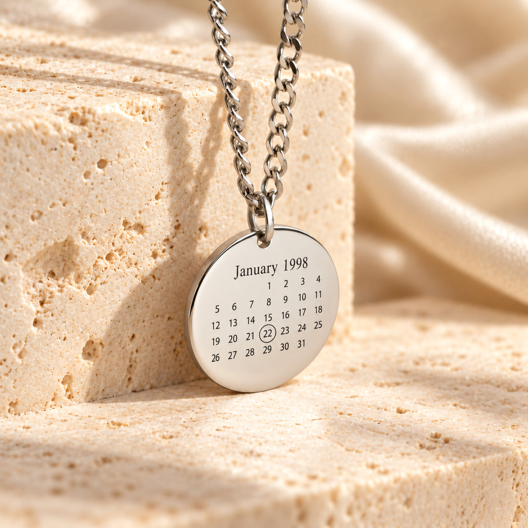 Silver calendar necklace pendant shown on a curb chain
