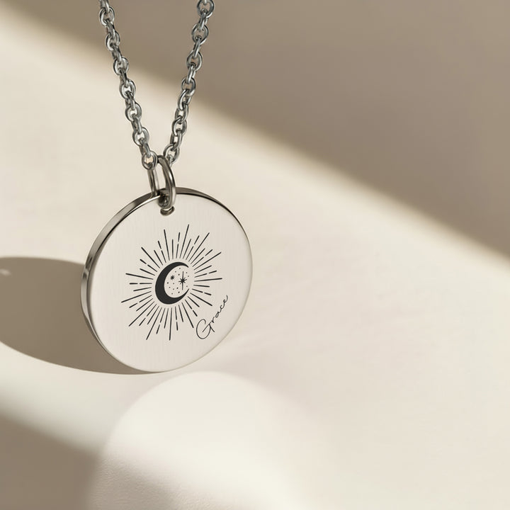 Silver celestial name necklace engraved with sunburst moon and stars design