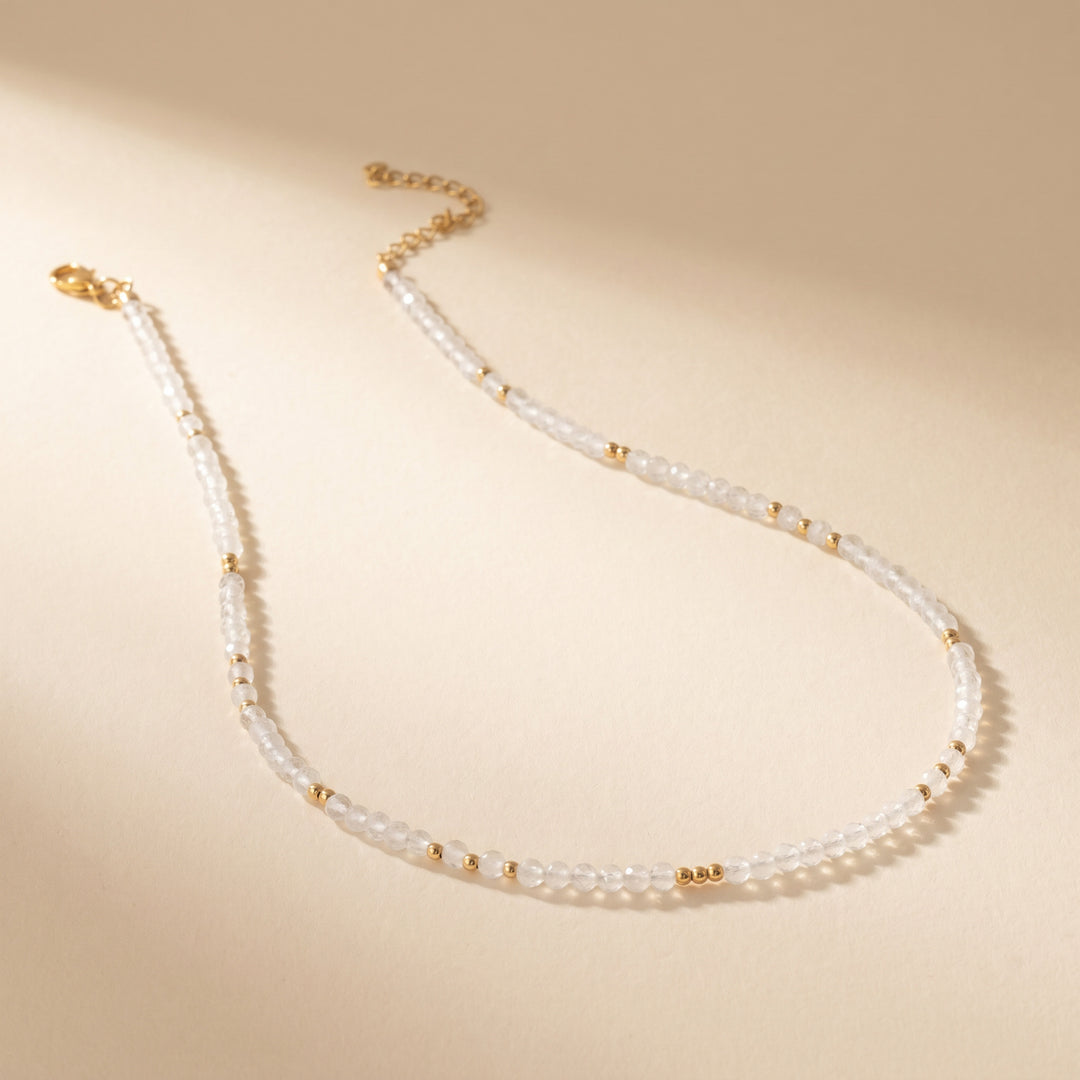 Real clear quartz necklace flat lay — full strand with lobster clasp and 2" extender detail