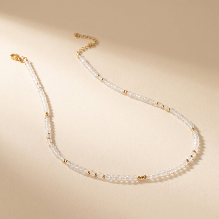 Real clear quartz necklace flat lay — full strand with lobster clasp and 2" extender detail