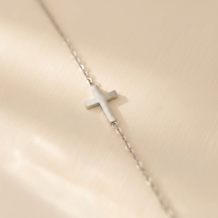 Silver sideways cross necklace on a fine cable chain