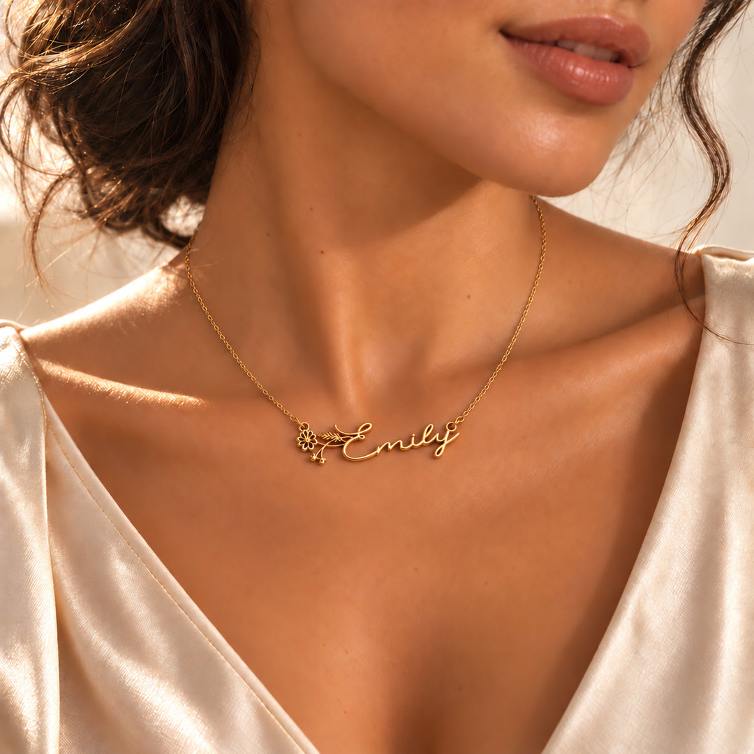 Gold birth flower name necklace with the name Emily and a daisy stem, worn on the neck
