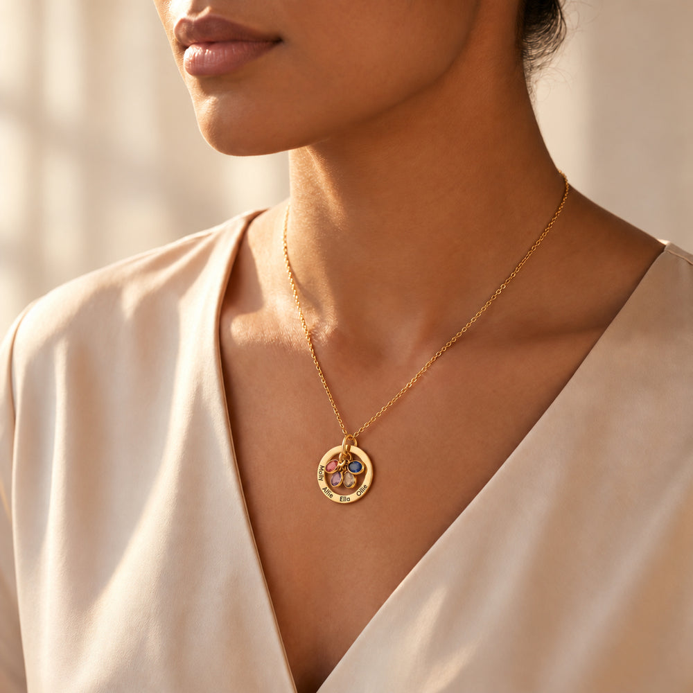Model wearing a gold family birthstone necklace with engraved names and birthstone charms