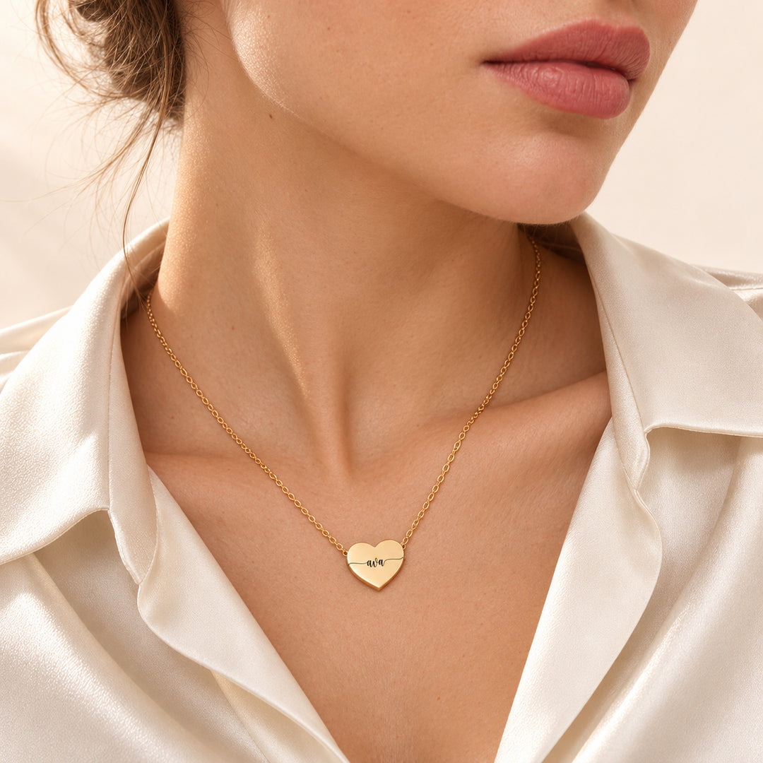 Gold heart name necklace engraved with the name Ava, worn on the neck