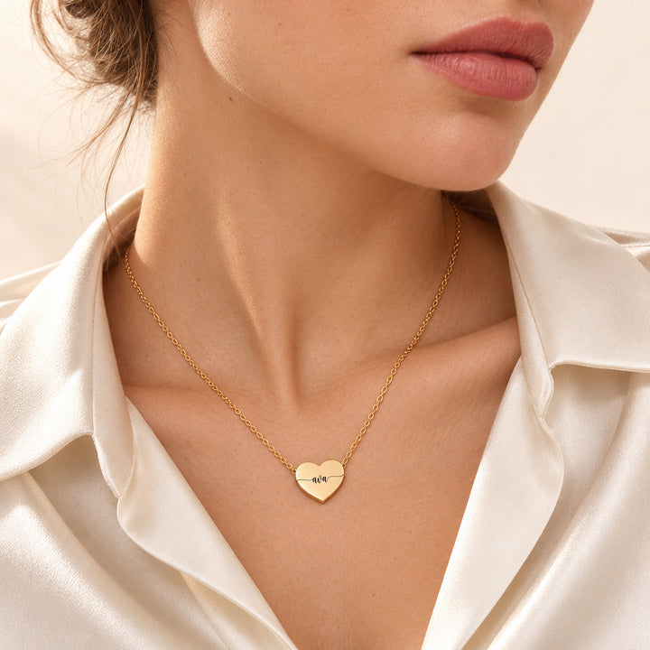 Gold heart name necklace engraved with the name Ava, worn on the neck