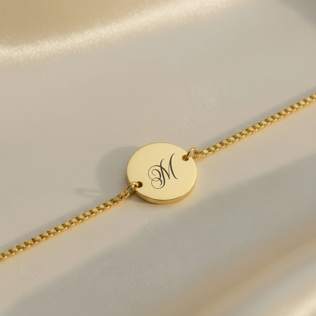 Gold personalised initial bracelet — engraved script letter on polished disc
