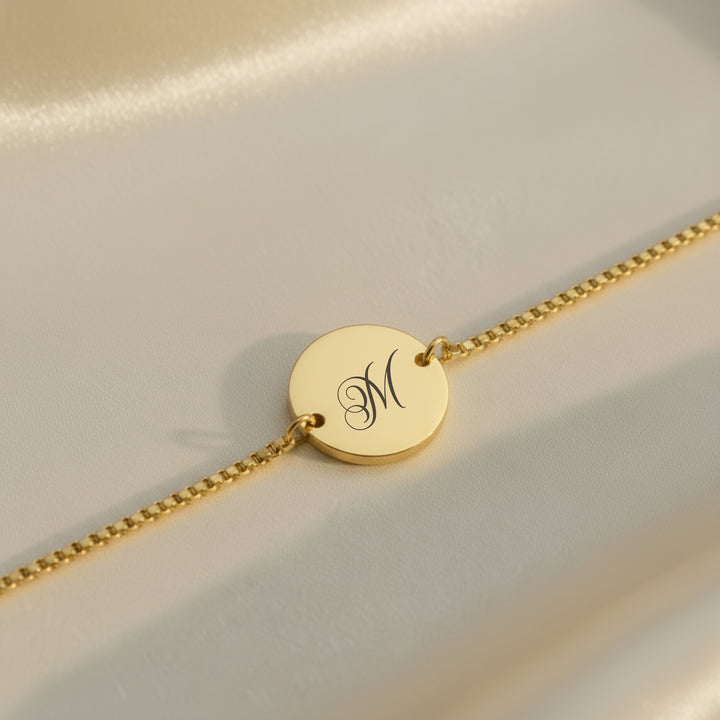 Gold personalised initial bracelet — engraved script letter on polished disc