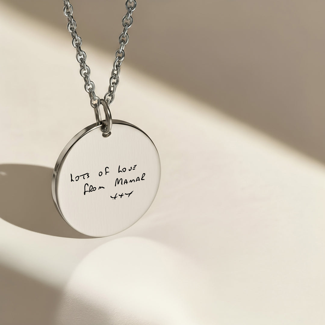 silver disc necklace engraved with handwriting