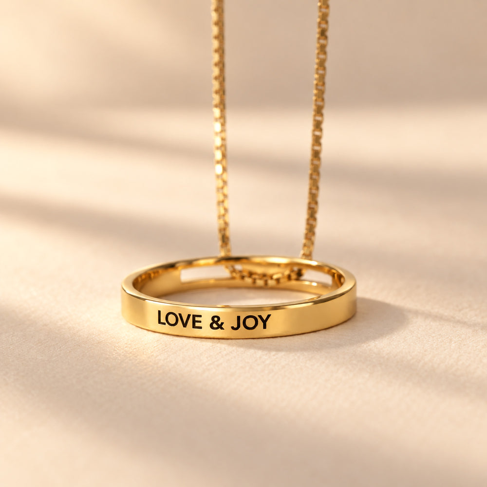 Gold circle necklace engraved LOVE & JOY on the outside