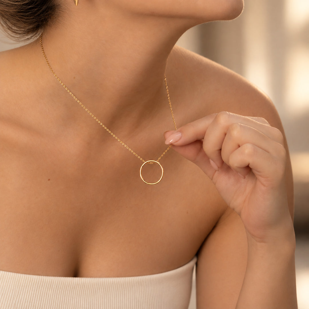 Gold open circle hidden message necklace worn on model