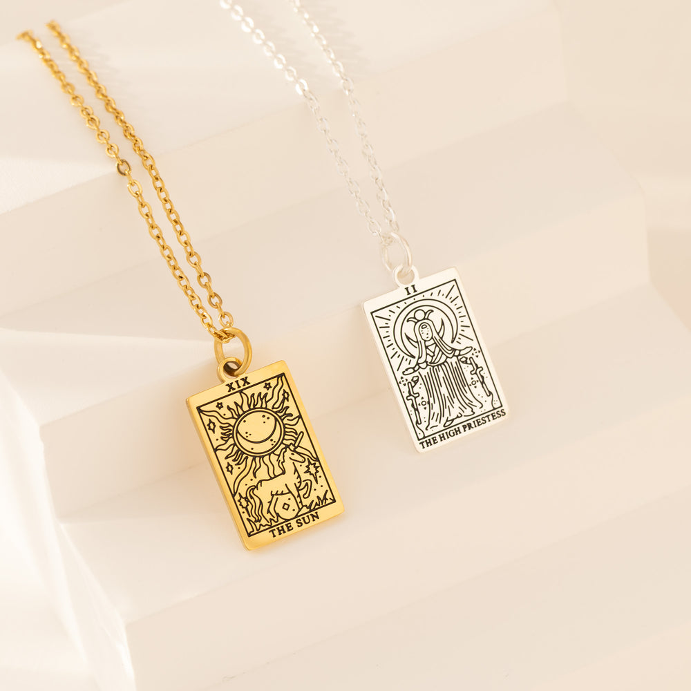Gold and silver tarot card necklace pendant on neutral background
