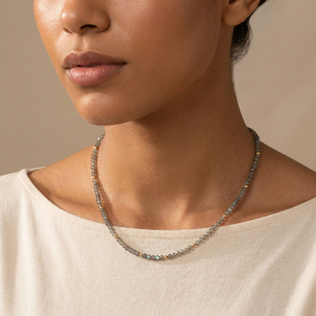 Real labradorite necklace on model — hand-strung in our Chester studio, iridescent blue-gold flash