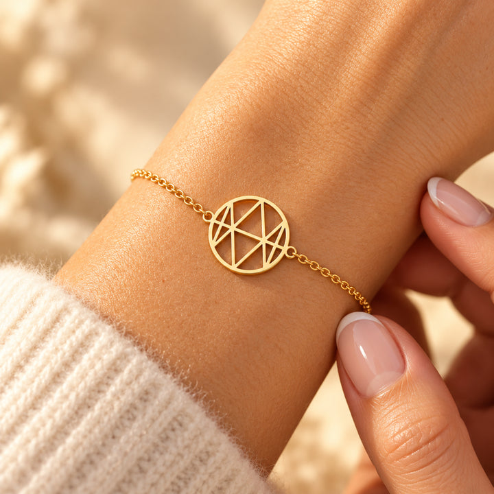Gold monogram name bracelet with the name Emma, worn on the wrist