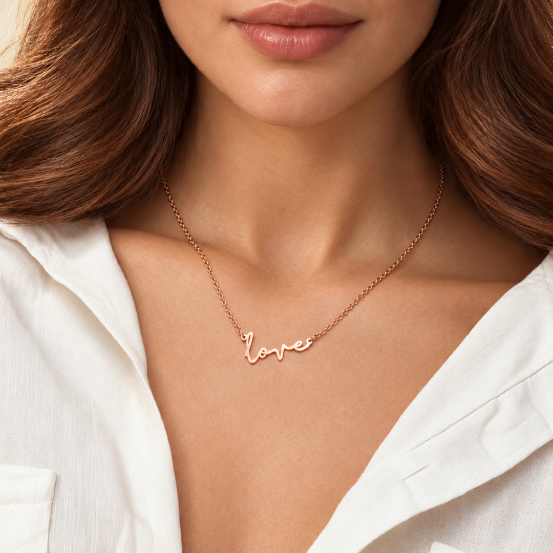 Model wearing a rose gold love script necklace