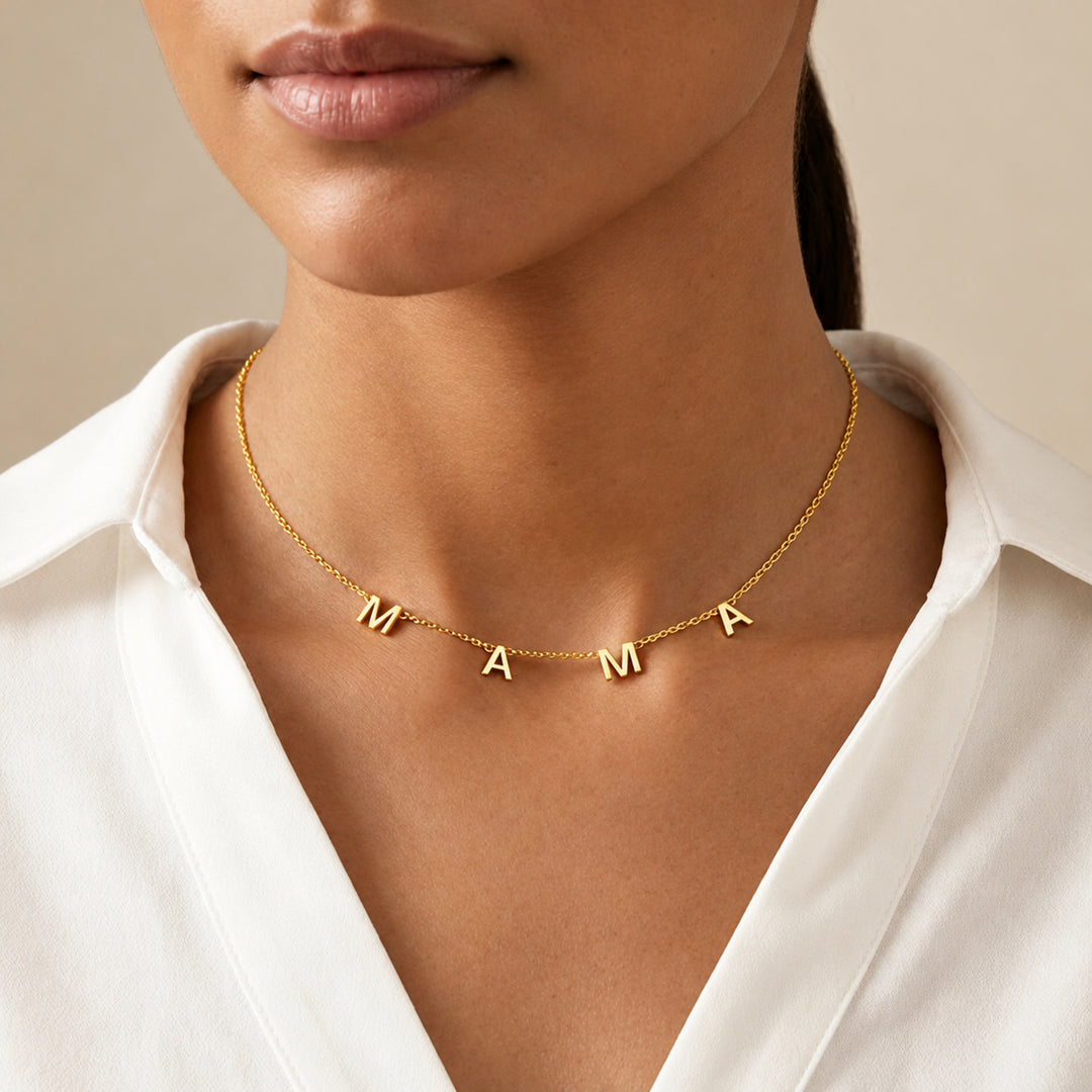 Model wearing a gold MAMA letter necklace with four separate letter charms