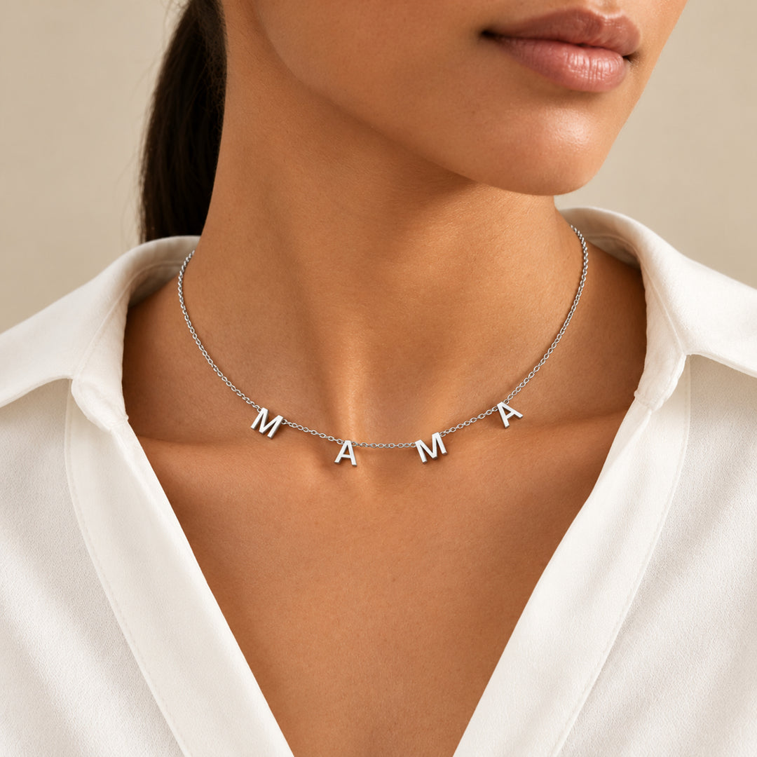 Model wearing a silver MAMA letter necklace with four separate letter charms