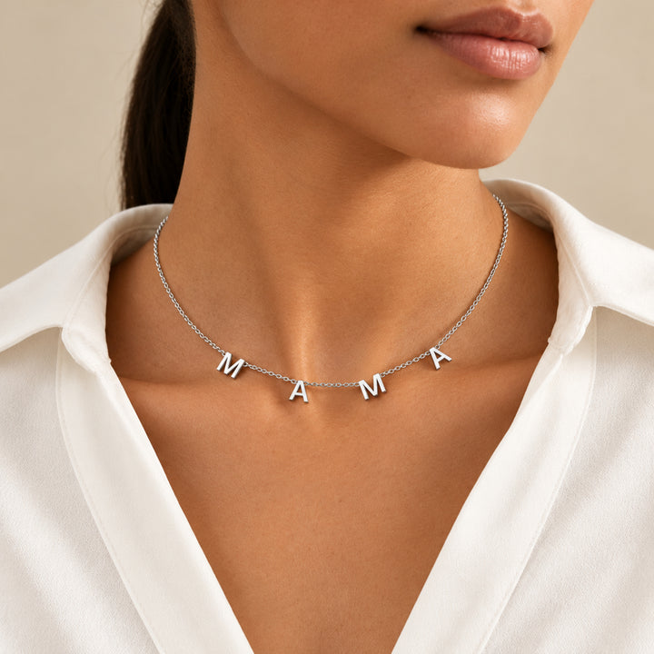 Model wearing a silver MAMA letter necklace with four separate letter charms