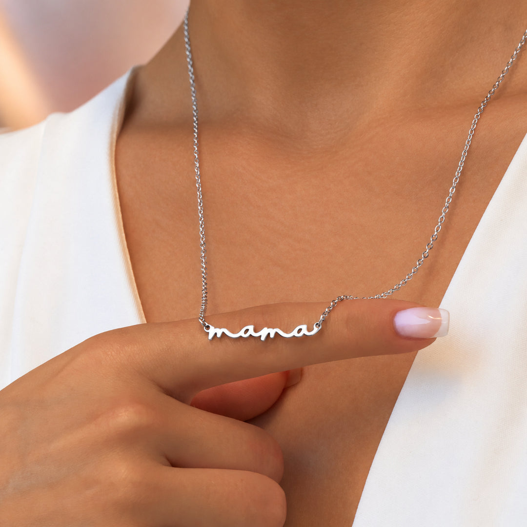 Model holding a silver mama necklace with the word mama in script