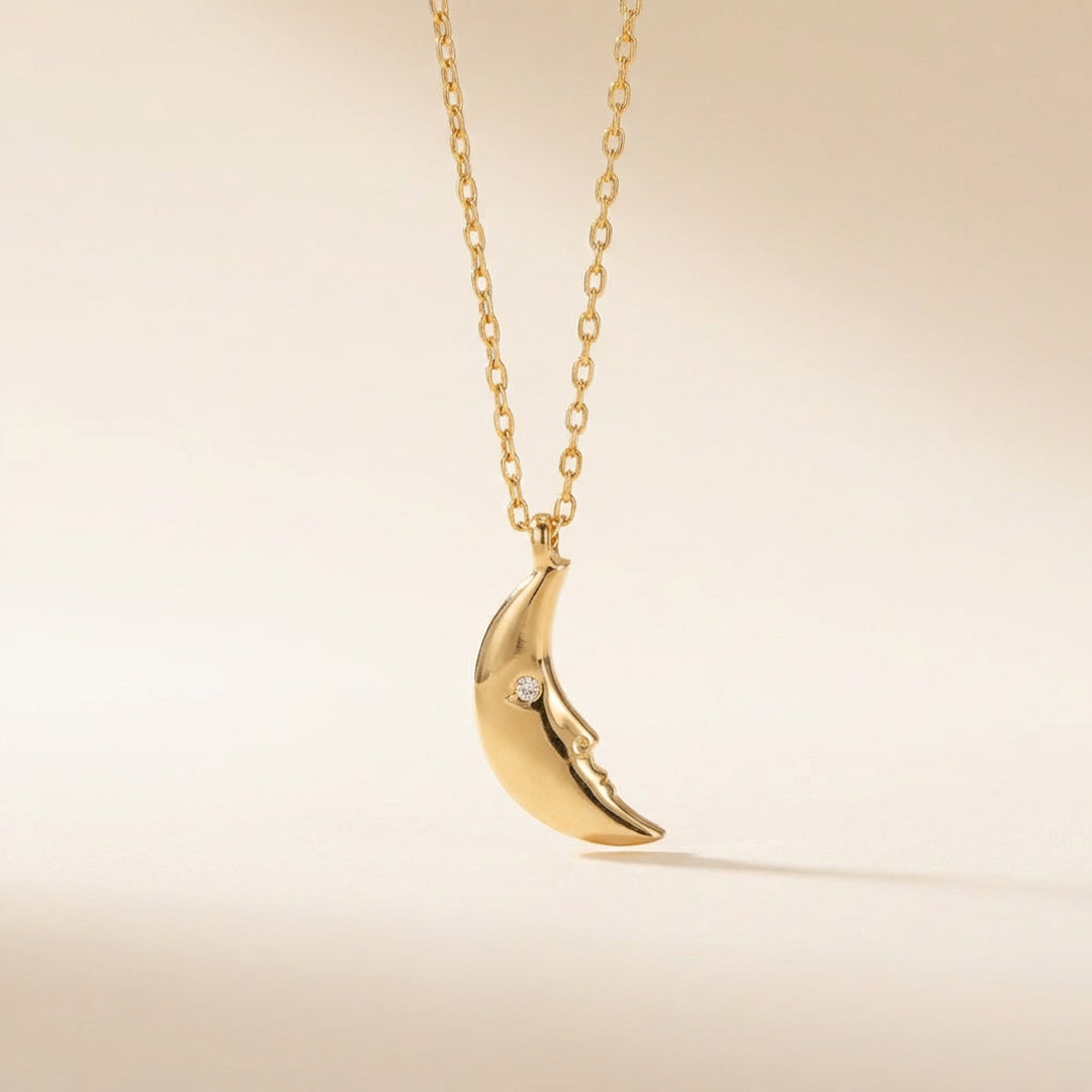 Gold crescent moon necklace with tiny stone on chain