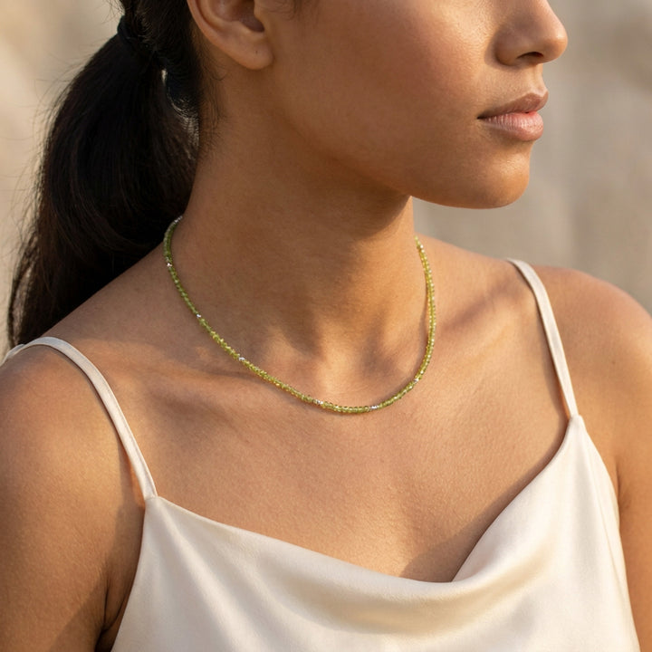 Sterling silver peridot necklace on model — chartreuse-green detail, hand-strung