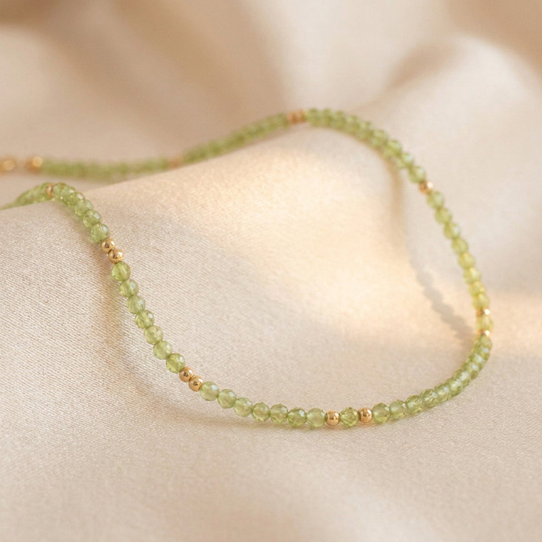 Real peridot necklace flat lay — full strand with lobster clasp and 2" extender detail