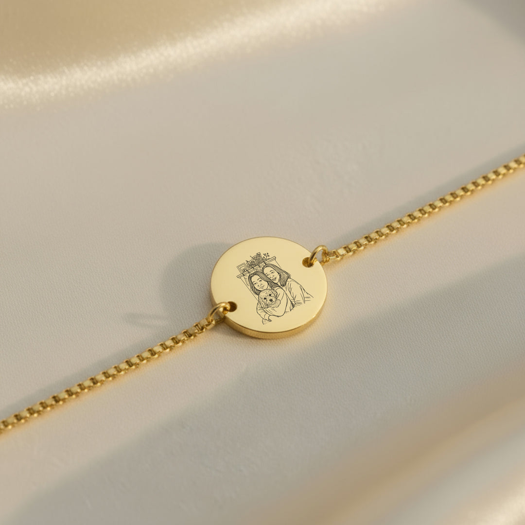Gold bracelet with a round photo engraved disc on a light background