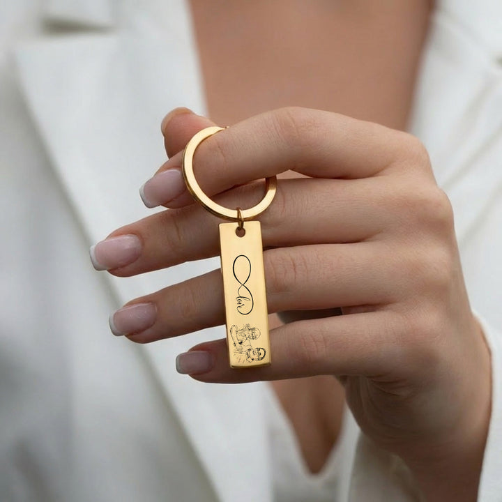 woman holding gold personalised photo keyring bar with engraved infinity design