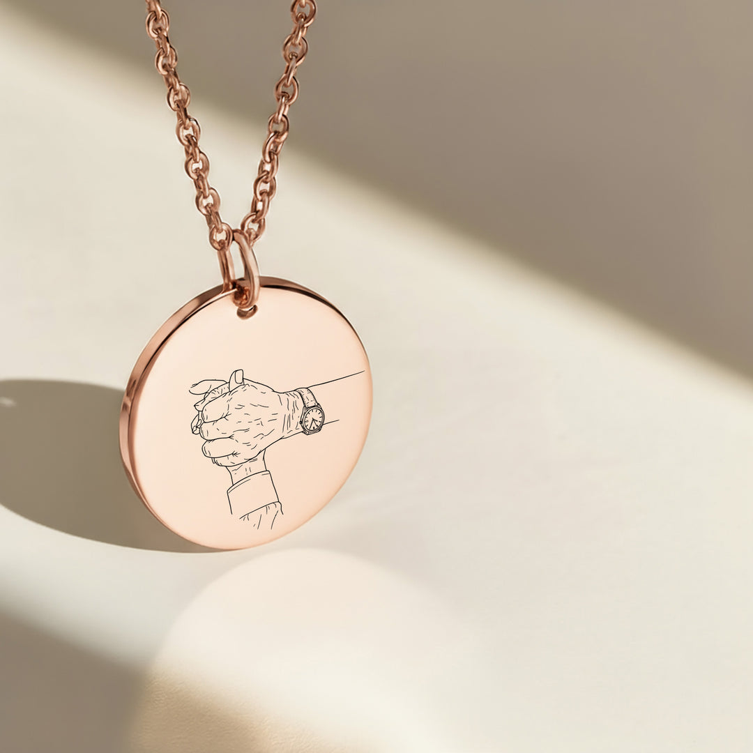 Holding hands photo engraved on a round rose gold pendant
