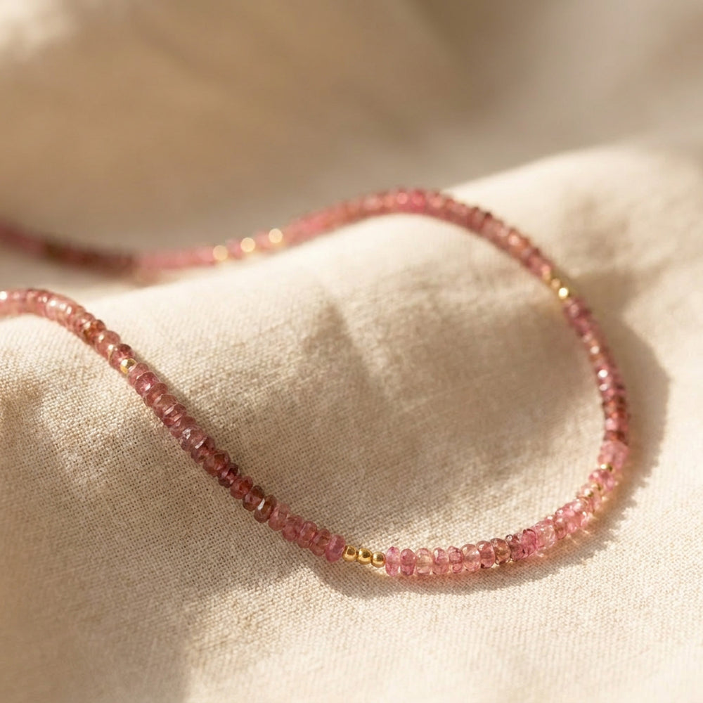 Real pink tourmaline necklace close-up — hand-cut, naturally shaded pink beads, hand-strung detail