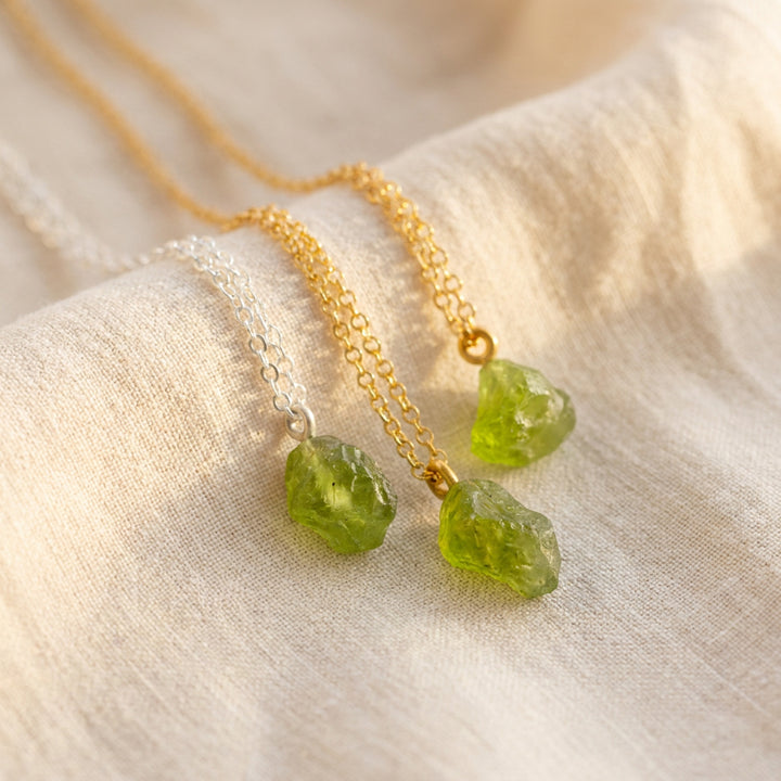 Raw peridot pendant necklaces — natural August birthstone crystals in different shapes and shades, on silver and gold PVD chains