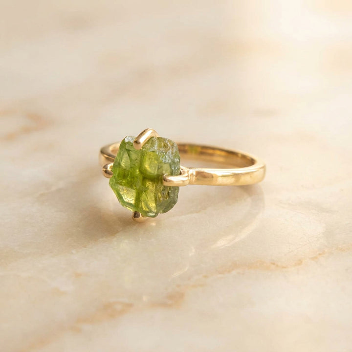 Gold vermeil raw peridot ring shown at an angle— August birthstone with natural uncut stone