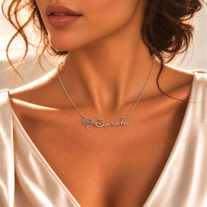 Silver birth flower name necklace with the name Sarah and a rose, worn on the neck
