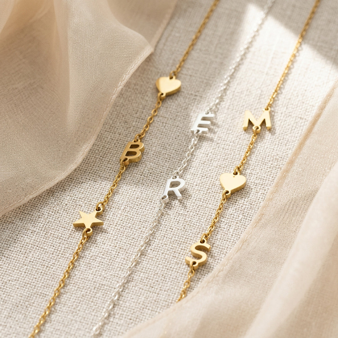 Personalised initial bracelet styled in gold and silver — letter pendants on dainty chain