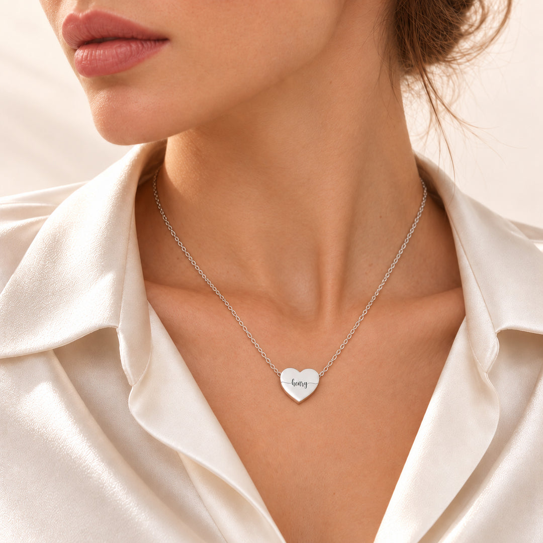 Silver heart name necklace engraved with the name Henry, worn on the neck