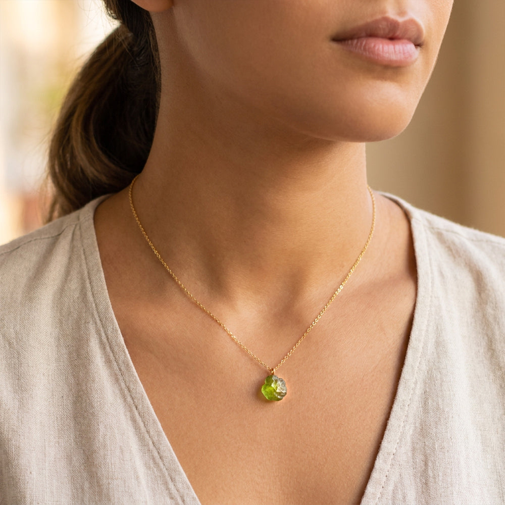 Raw peridot necklace worn on model — gold PVD chain, natural August birthstone pendant, heart chakra crystal from Abiza